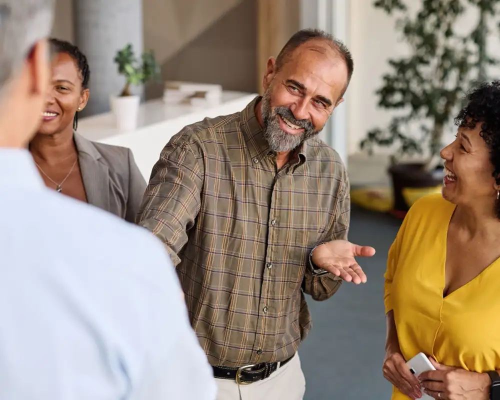 Community partners talking and laughing together in a bright office